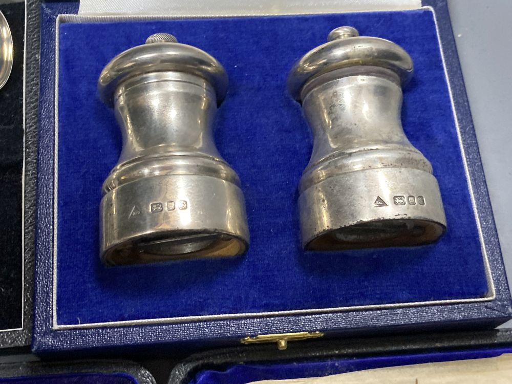 A cased pair of modern silver salt and pepper grinders, 74mm and two cased sets of six silver coffee spoons